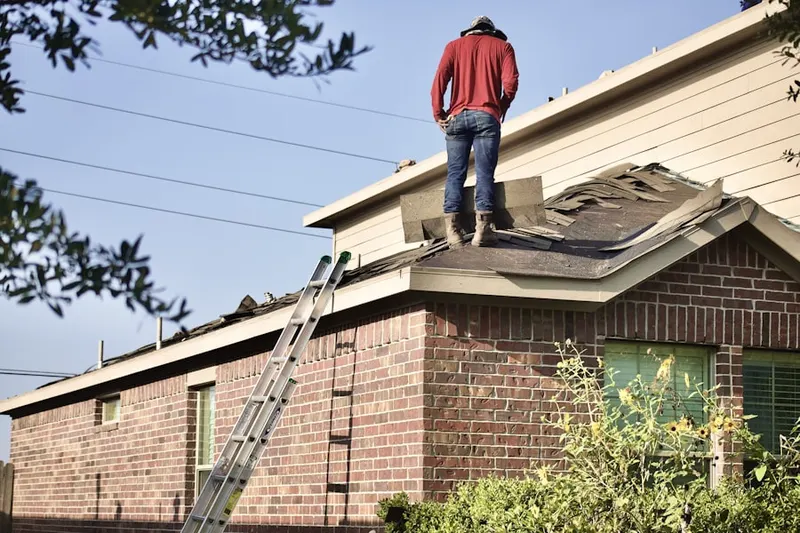 Professional roofer working on a residential roof in Daybreak